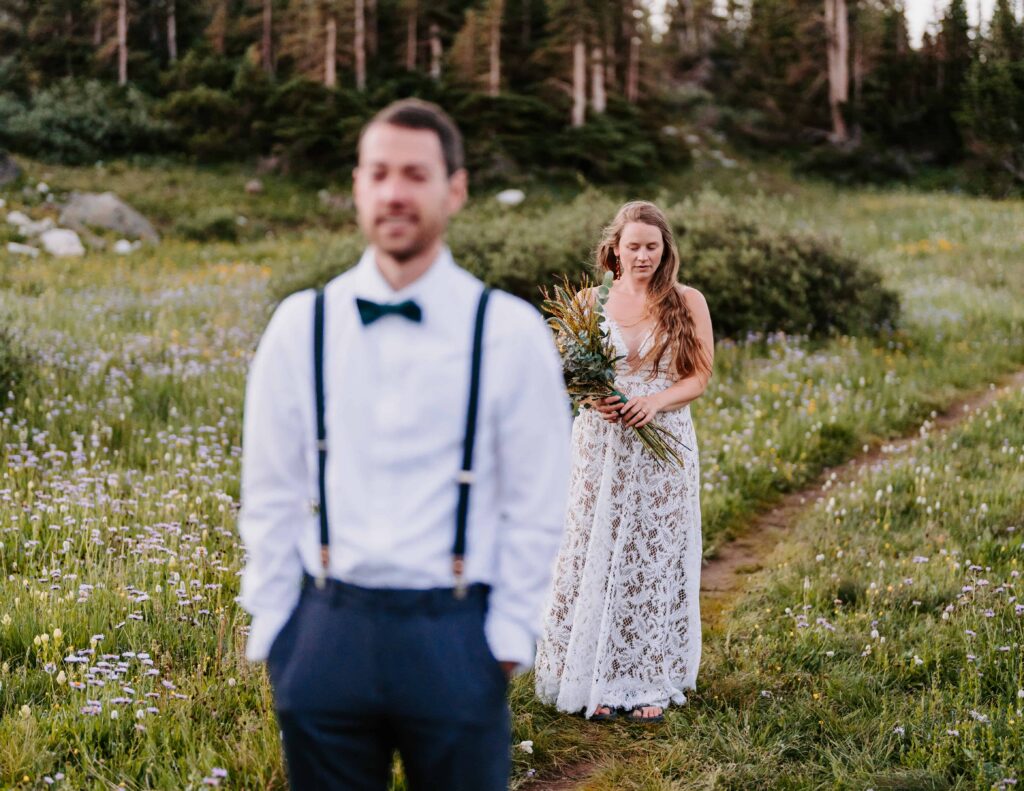 Bride walks behind groom for their first look on their elopement day