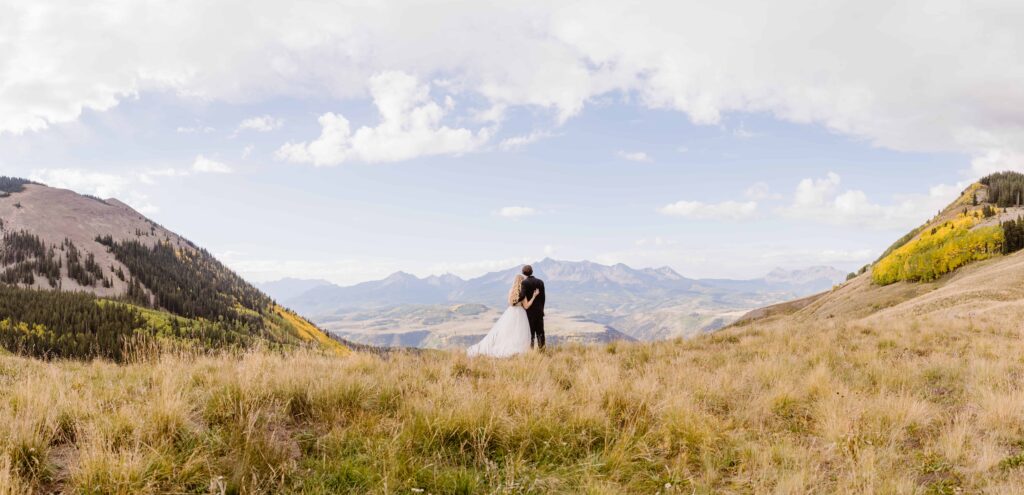 Couple stands together looking at the San Juan Mountains in Colorado