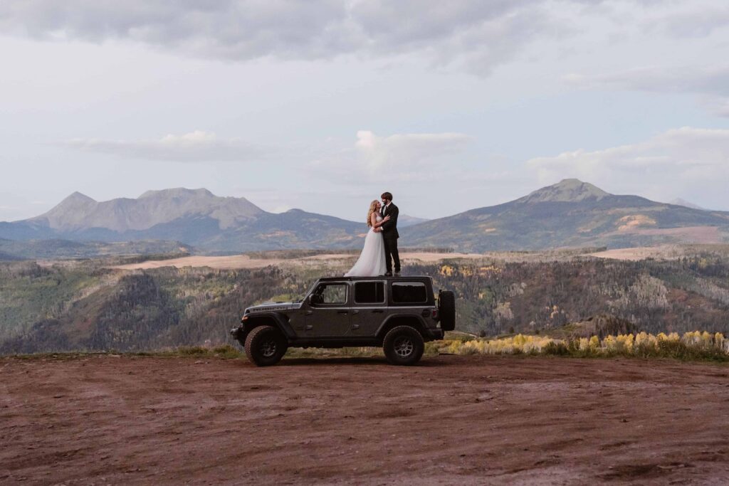 Couple stands on Jeep on the San Juan Mountains in Colorado