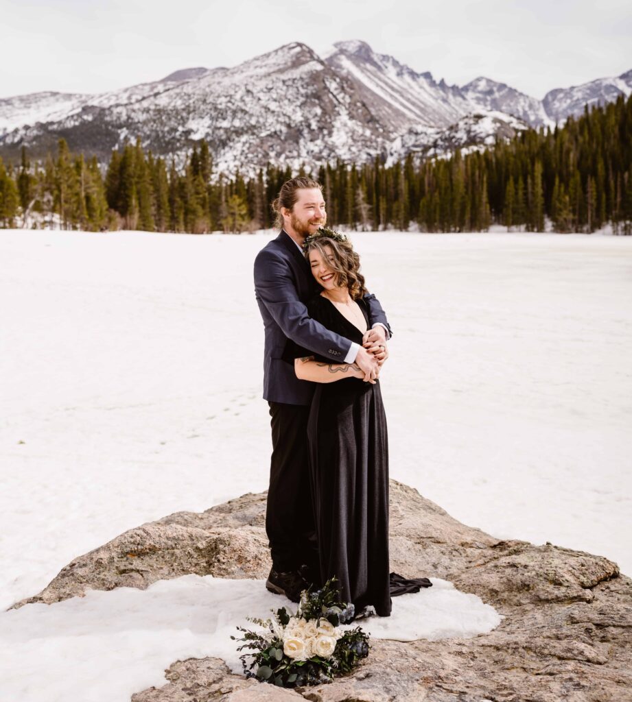 Bride snuggles into groom during their winter Rocky Mountain National Park elopement