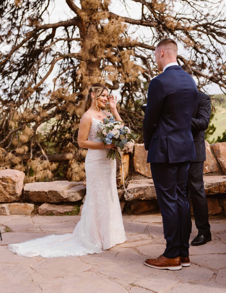 Bride wipes tears away during mountain wedding in Boulder, Colorado