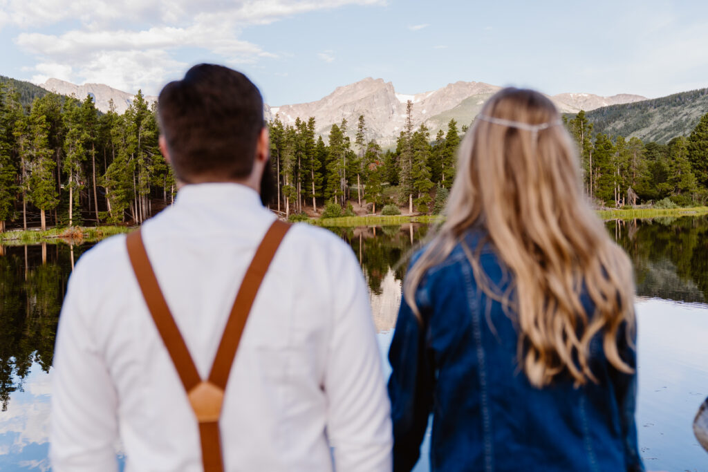 Couple looks out at Sprague Lake during their Rocky Mountain National Park elopement
