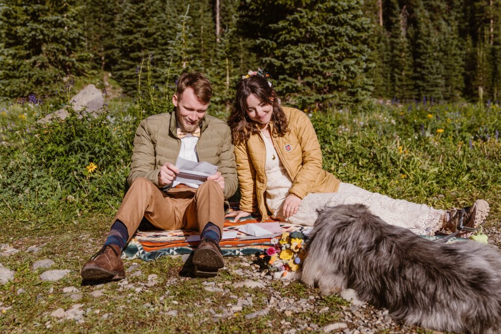 Couple reads letters from their family while having a picnic during their elopement in Colorado