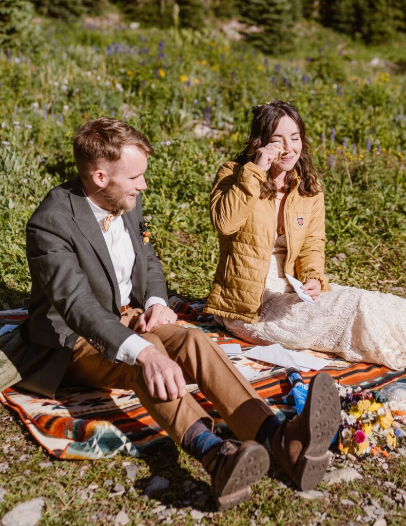 Couple reads letters from their family while having a picnic during their elopement in Colorado