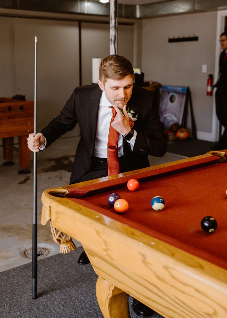 Groom plays pool on his wedding day