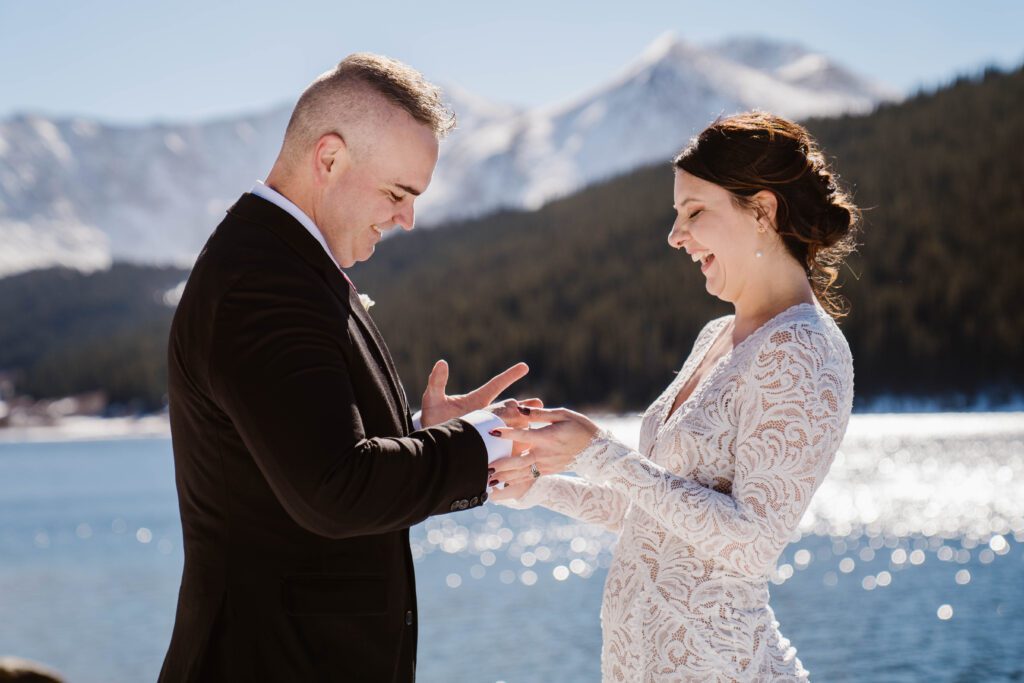 Bride laughing while exchanging rings during Breckenridge Colorado winter elopement