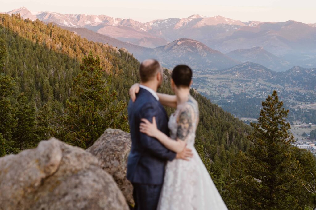 Bride and groom embrace while admiring sweeping Rocky Mountain National Park views during their elopement.