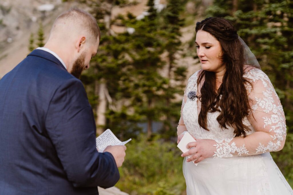 Emotional moment as bride listens while groom reads heartfelt vows during their Lake Isabelle elopement
