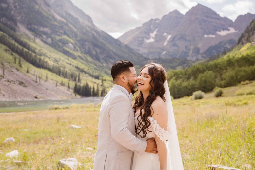 Couple laughing together during their Maroon Bells elopement with the iconic twin peaks in the background in Aspen, Colorado
