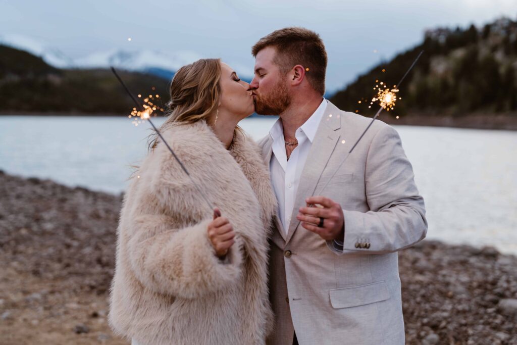 Couple kisses at dusk with sparklers 