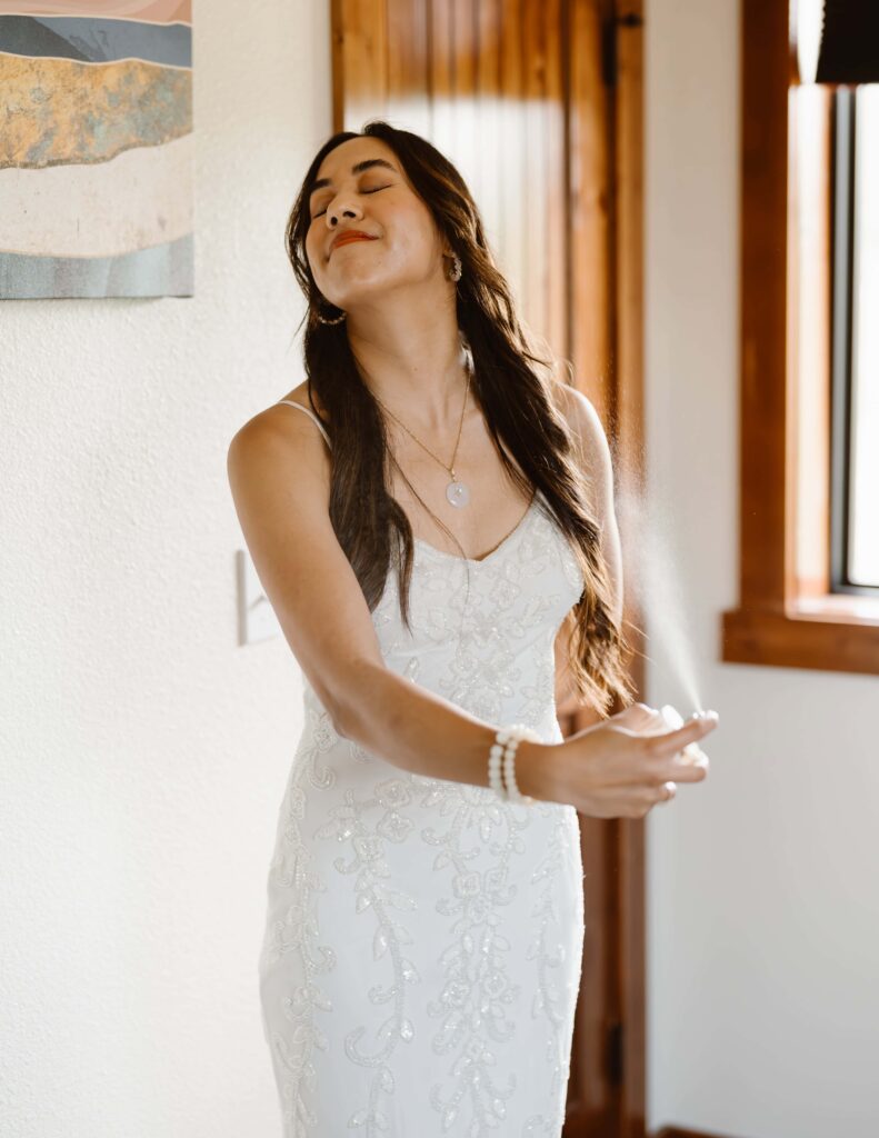 Bride misting on perfume while getting ready.