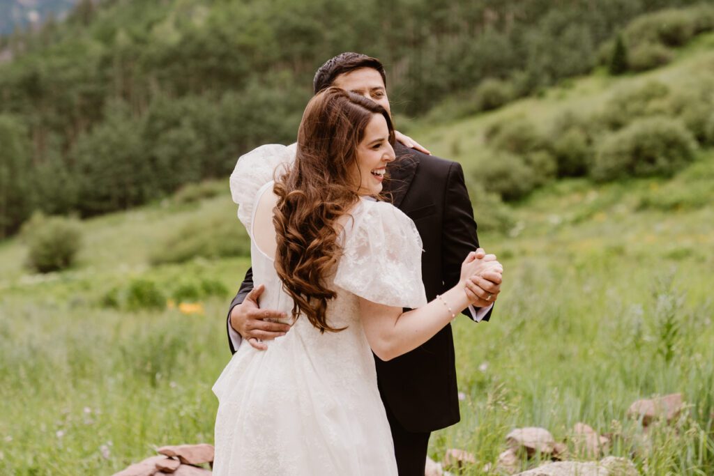 Wedding portraits of a bride and groom in the summertime at the Maroon Bells Amphitheater in Aspen, Colorado