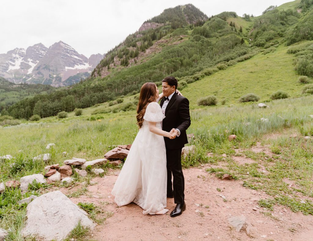 Wedding portraits of a bride and groom in the summertime at the Maroon Bells Amphitheater in Aspen, Colorado