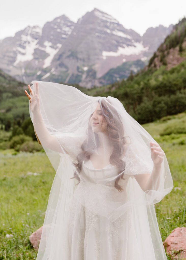 Wedding portraits of a bride and groom in the summertime at the Maroon Bells Amphitheater in Aspen, Colorado