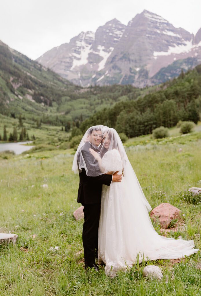 Wedding portraits of a bride and groom in the summertime at the Maroon Bells Amphitheater in Aspen, Colorado