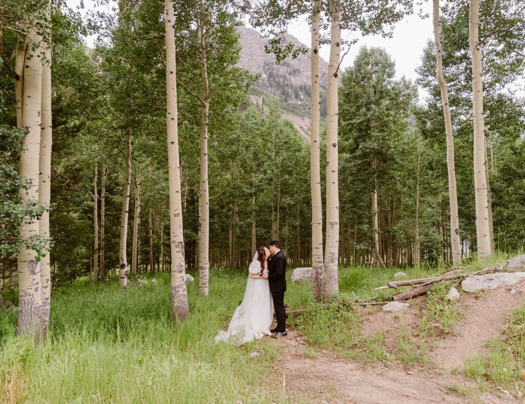 Wedding portraits of a bride and groom in the summertime at the Maroon Bells Amphitheater in Aspen, Colorado