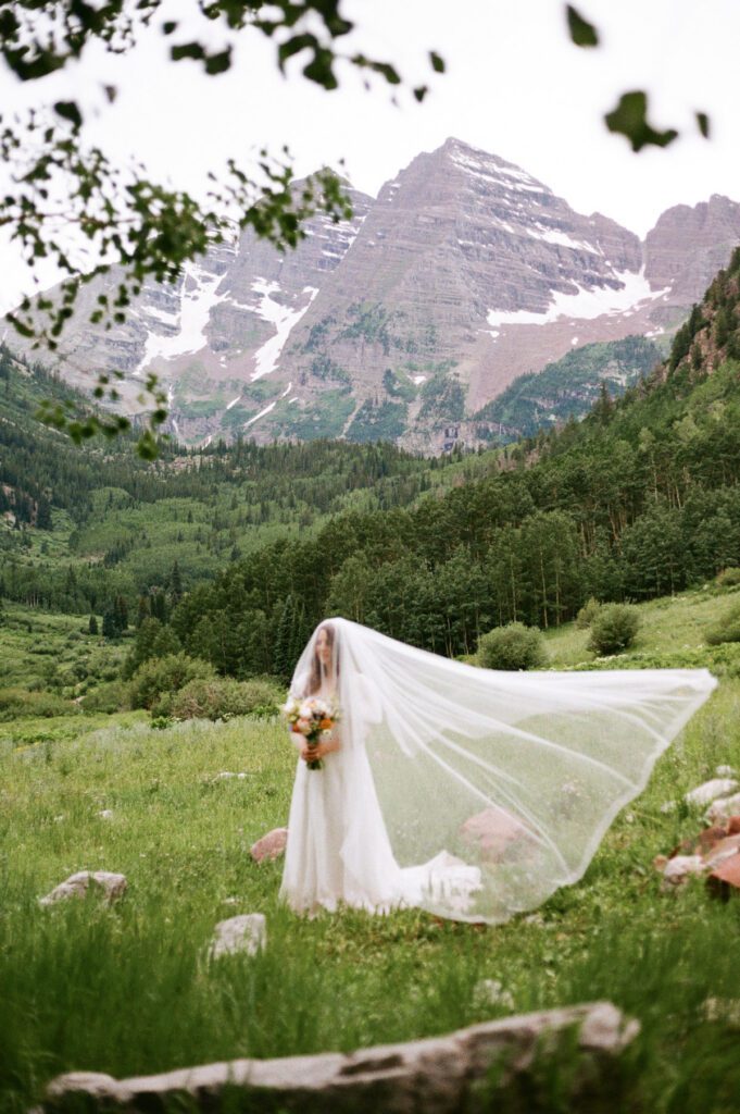 Film wedding portraits of a bride and groom in the summertime at the Maroon Bells Amphitheater in Aspen, Colorado