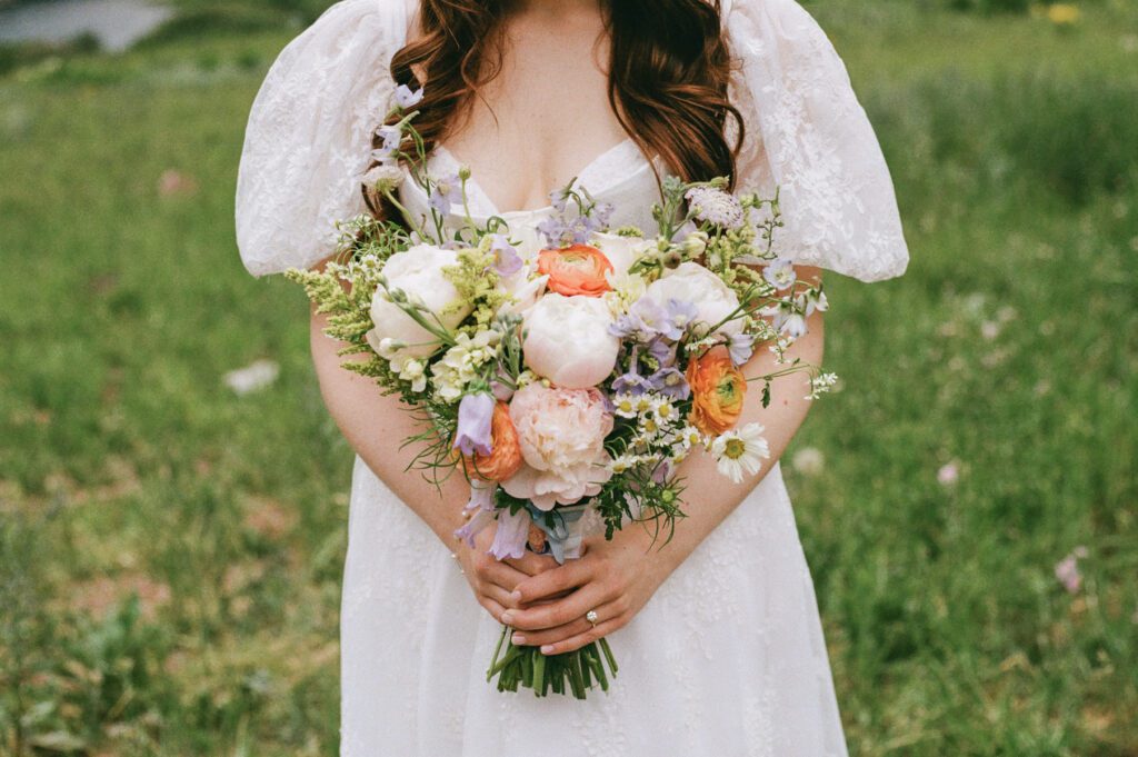 Film wedding portraits of a bride and groom in the summertime at the Maroon Bells Amphitheater in Aspen, Colorado
