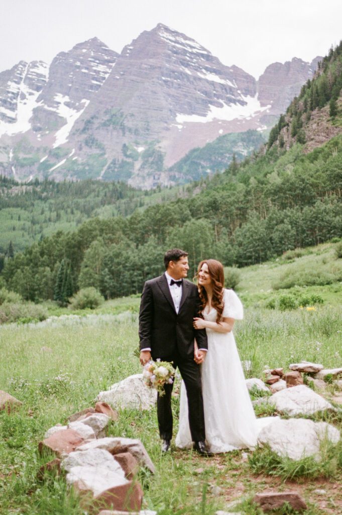 Film wedding portraits of a bride and groom in the summertime at the Maroon Bells Amphitheater in Aspen, Colorado