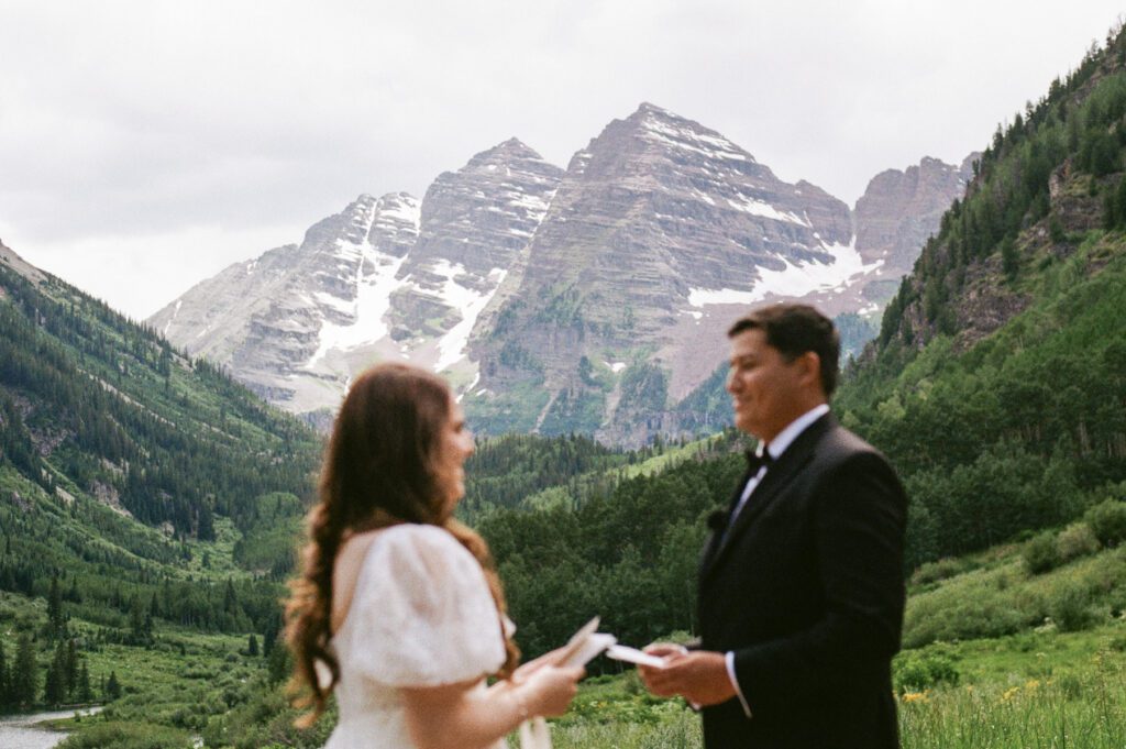 Film wedding portraits of a bride and groom in the summertime at the Maroon Bells Amphitheater in Aspen, Colorado
