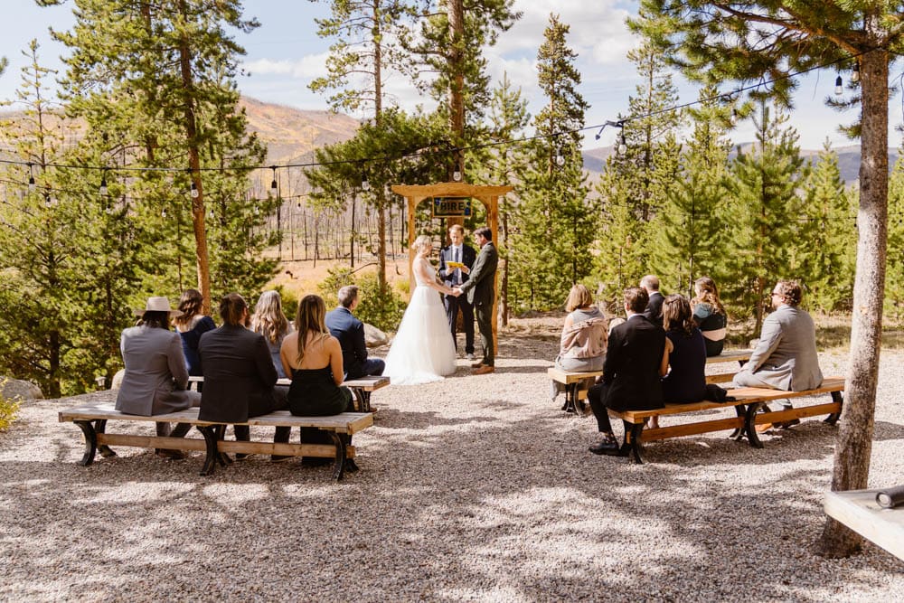 Couple holds hands while officiant marries them during their wedding in Granby, Colorado